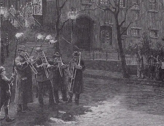 An image of the black and white engraving published in Harper’s Weekly featuring the Bethlehem Moravian trombone choir. There are four men playing trombones, and four lads with torches stand near them or behind them so they can see their music. The streets are cobblestone, and there are a group of people making their way towards the church on the sidewalk. At the top of the engraving are the church steps, with many people lined up to get in to the church.