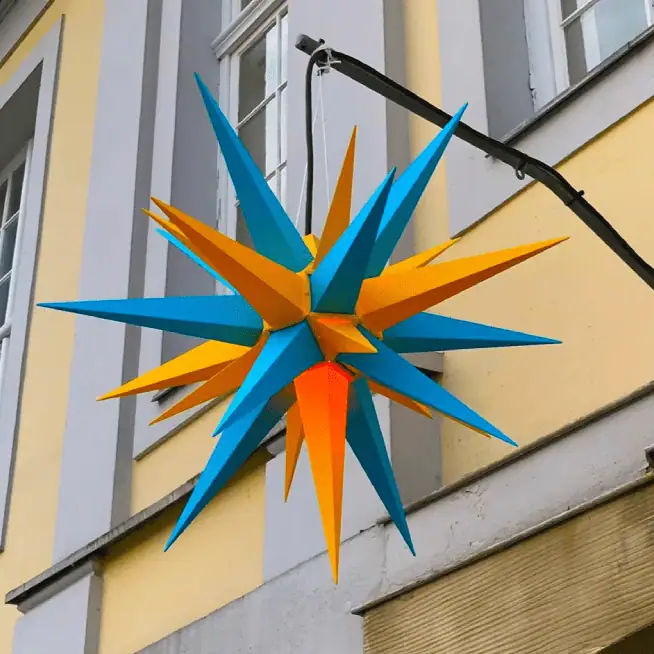 A bright blue and orange Moravian Star hanging above the door of the Herrnhut offices of the European Continental Province of the Moravian Church.