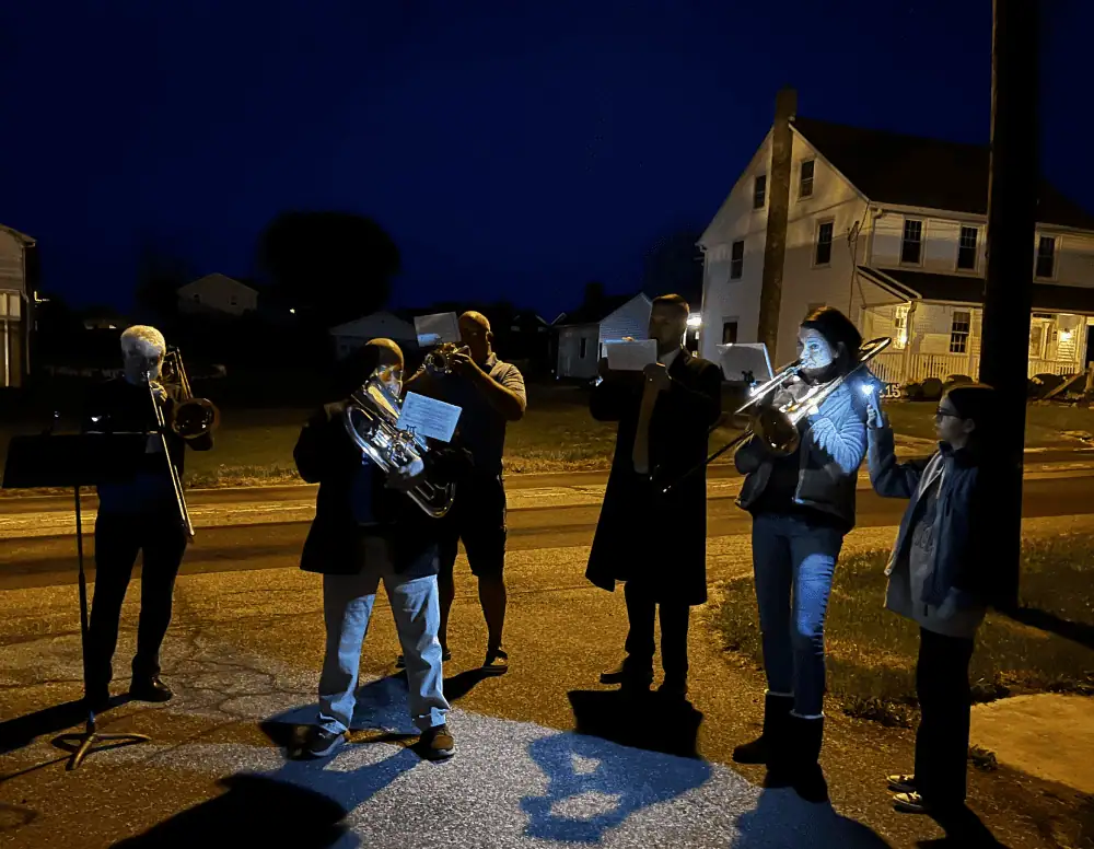 Six members of the Schoeneck Brass Choir stand in the pre-dawn light play their instruments to announce the Easter Dawn and the Resurrection of our Lord.