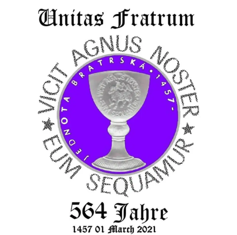 A logo celebrating 564 years of the Unitas Fratrum in 2021. In the center of the image is a translucent white glass chalice with the official seal of the Moravian Church etched on it. The chalice sits inside a periwinkle blue circle with the words "Jednota Bratska 1457" curved around the chalice. The periwinkle blue circle is surrounded by the official motto of the Moravian Church in Latin: Vicit Agnus Noster, Eum Sequamur.