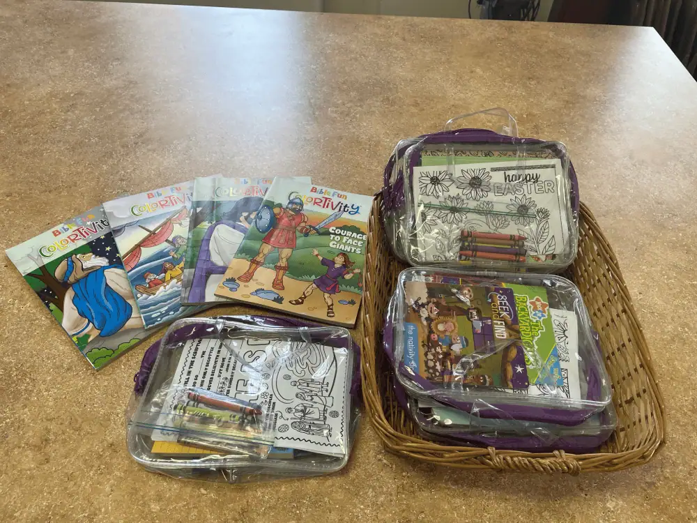 The children's activity bags are on a counter in the Diener's Kitchen. The bags are clear to display what's inside - story books, coloring books, activity pages, and crayons.