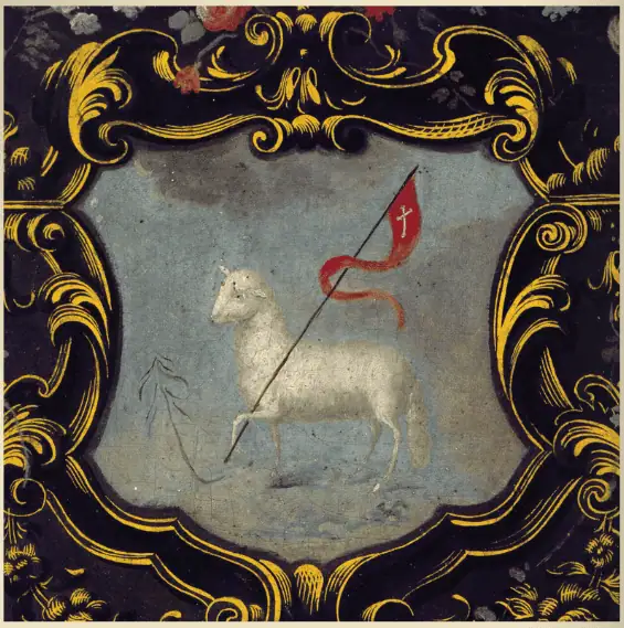 An old image of the Angus Dei. The lamb is very simple. It is facing forward with the leg closest to the viewer cocked and holding a staff. From the staff flies a this red flag with a gold cross. The lamb image is surrounded by an ornate frame of black and gold.