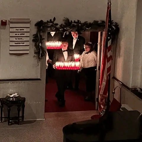 The sanctuary doors are opened to reveal the Dieners, ready with trays of lit Christmas candles as the congregation sings "Behold a great, a heavenly light!"