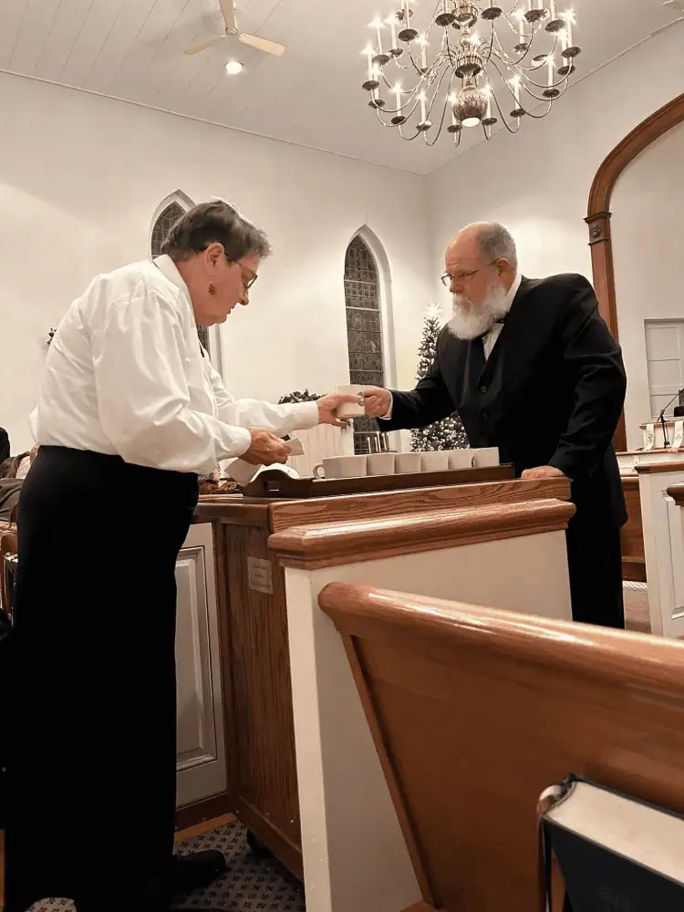 Two members of Schoeneck's Diener Corps are shown with a lovefeast cart as they serve the congregation.