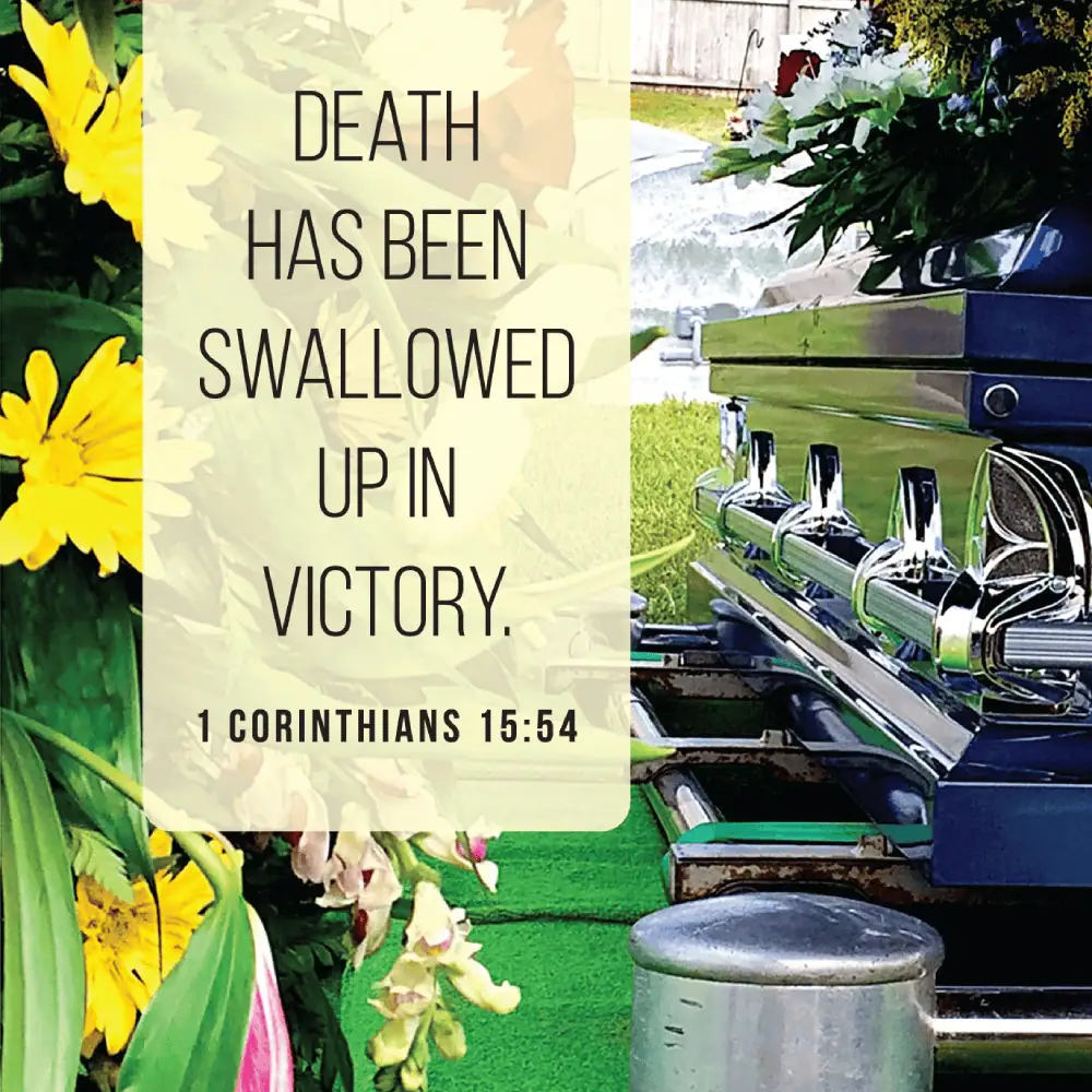 A picture of a black coffin is surrounded by flowers. The scripture text from 1 Corinthians 15:54 is written in a yellow block: Death has been swallowed up in victory.
