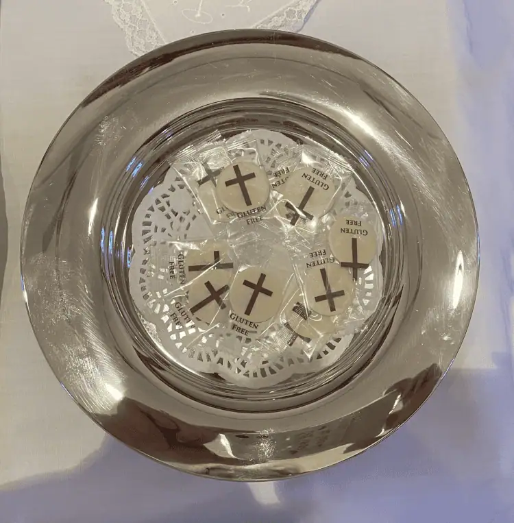 A communion plate with individually wrapped gluten-free wafers.
