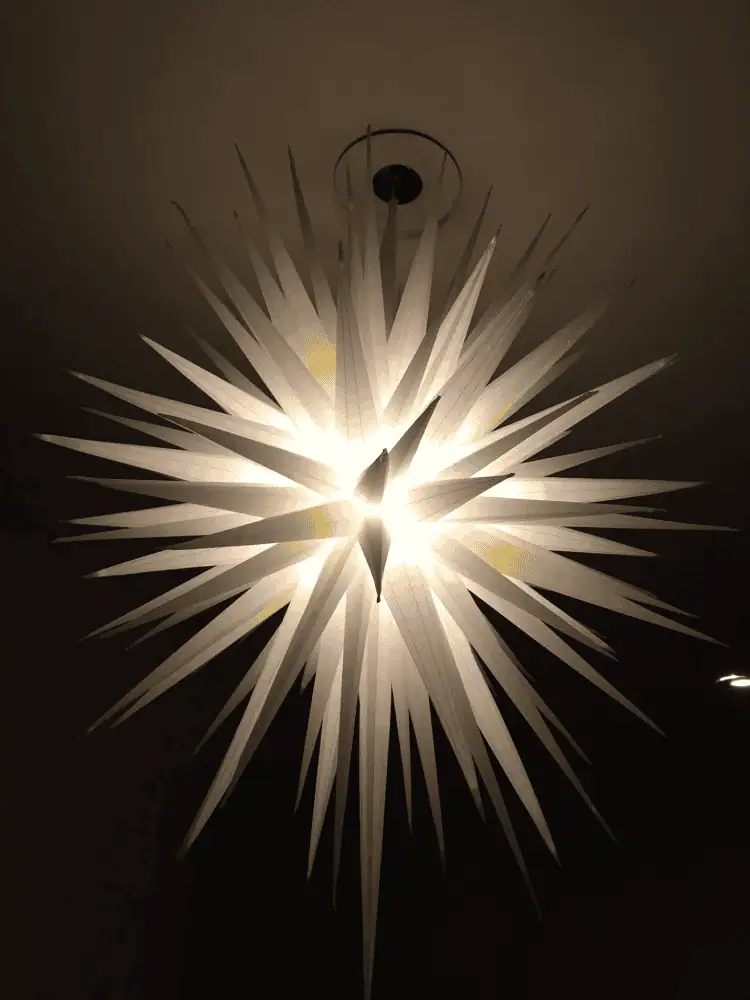 A lit white 110 point Moravian star hanging at Home Moravian Church in Winston-Salem, North Carolina.