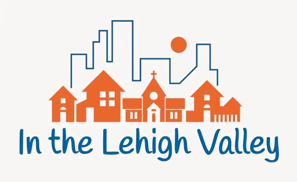 A clip-art image featuring small town buildings in orange with the outline of large city buildings behind it in azure blue. The text is also in azure blue and reads "In the Lehigh Valley."