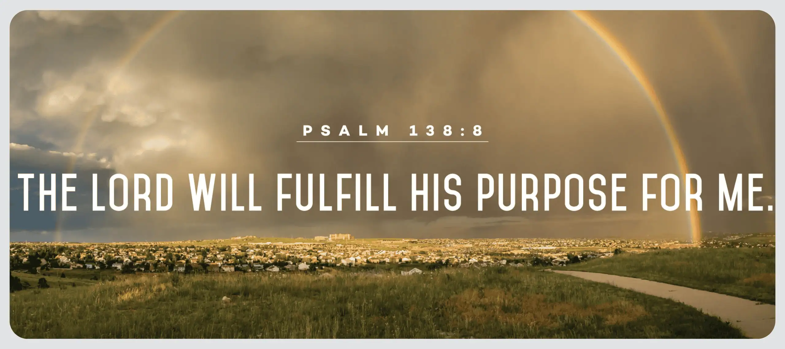 The words from Psalm 138:8 "The Lord Will Fulfill His Purpose For Me" are placed over an image of a town at a distance. The sky is both cloudy and blue, and a full rainbow arcs overs the town.