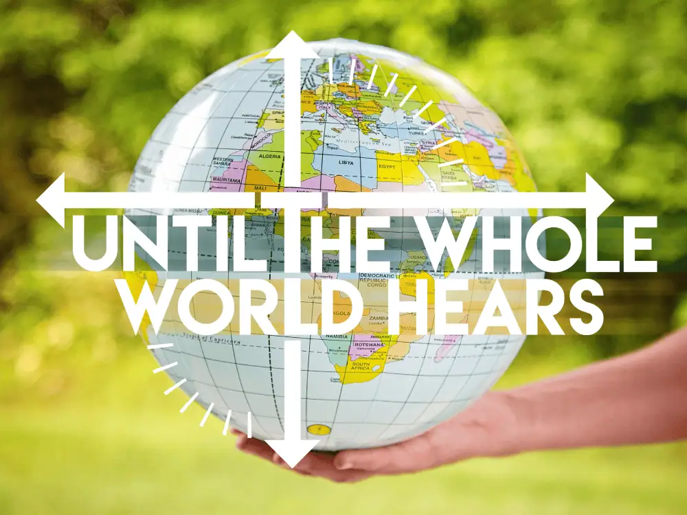 Someone holds a blow-up globe against a backdrop of the outdoors. The picture has the words "Until the whole world hears" across it.