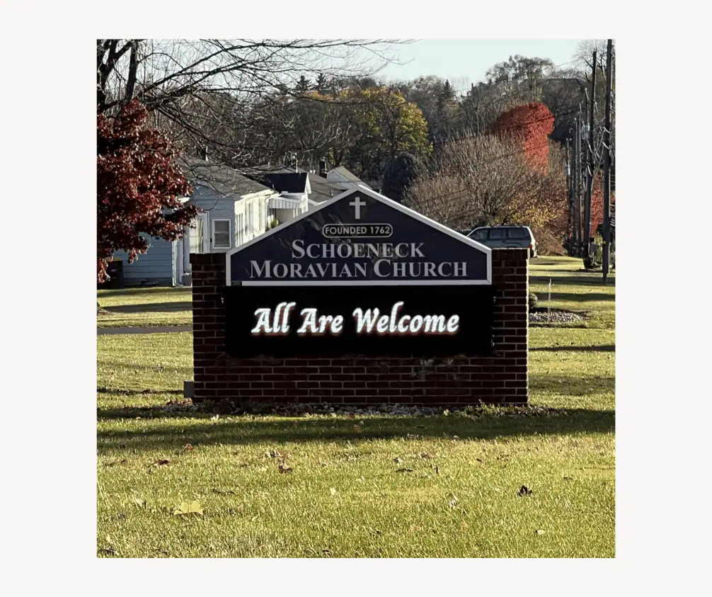 Schoeneck's Church sign - a brick enclosure for an LED sign. The top of the sign is a triangular shape with "Schoeneck Moravian Church - Founded 1762" written on it. The LED sign says, "All Are Welcome". Schoeneck's Church sign - a brick enclosure for an LED sign. The top of the sign is a triangular shape with "Schoeneck Moravian Church - Founded 1762" written on it. The LED sign says, "All Are Welcome".