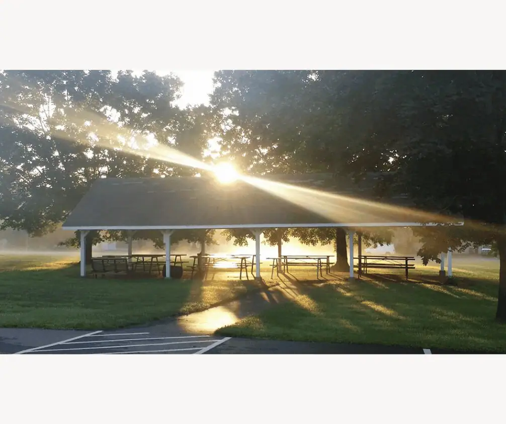 The early morning sun shines through the trees in the Grove illuminating the pavilion in a golden glow. The early morning sun shines through the trees in the Grove illuminating the pavilion in a golden glow.