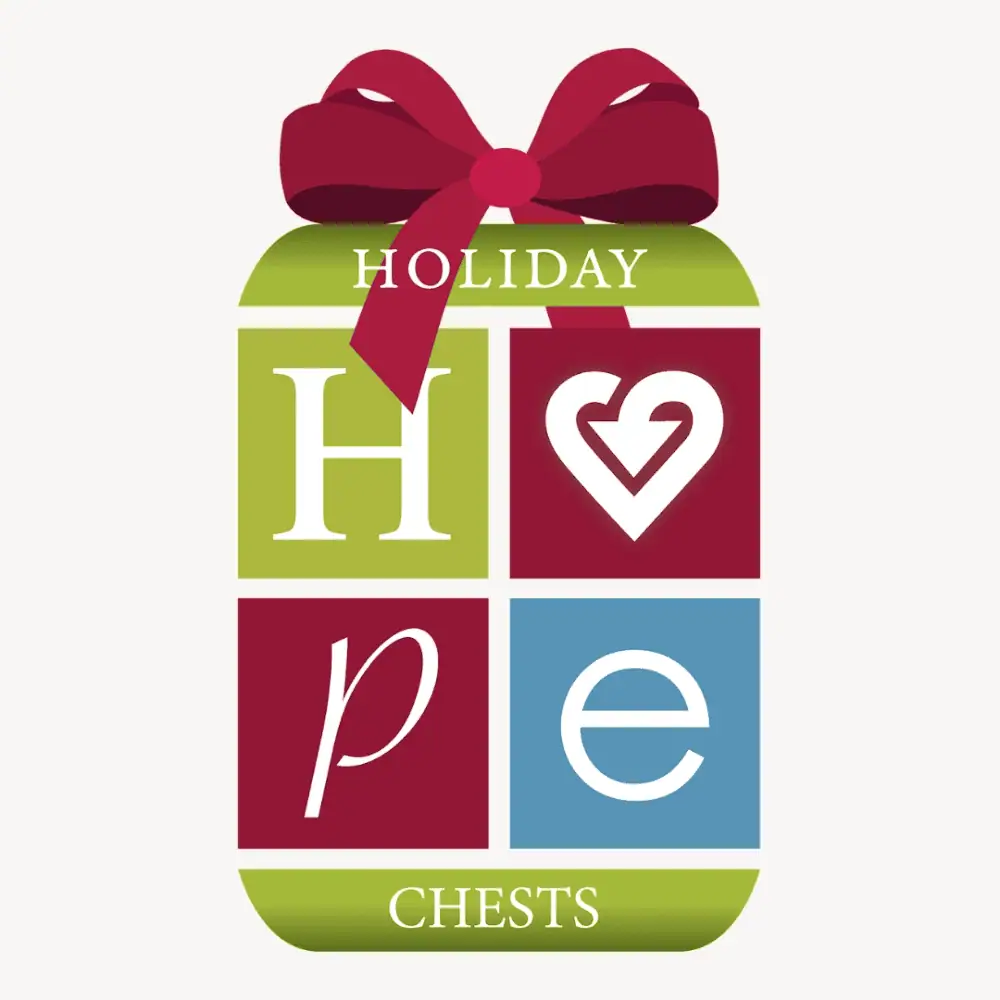 The logo for the Holiday Hope Chests program. A tall gift is wrapped in gold, burgundy, and light blue squares, with white in between them to suggest a ribbon. In each square is a letter - H, a heart for the O, a P, and an E. At the top is the word "Holiday" under a burgundy bow. At the bottom is the word "Chests" so that the whole image says Holiday Hope Chests.