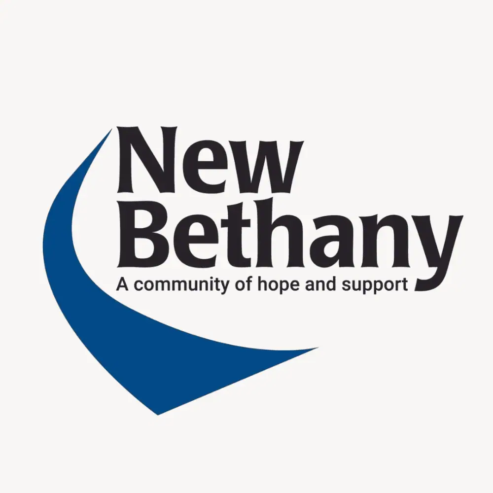 The logo for New Bethany Ministries. There is a blue royal road curving from the bottom of the text to the top. The text reads New Bethany: A community of hope and support.