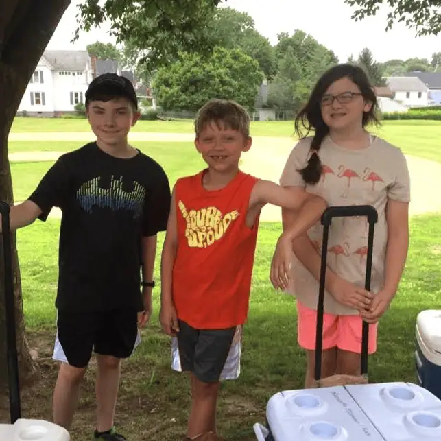 Two Schoeneckian boys and a girl pose together in Schoeneck's grove.
