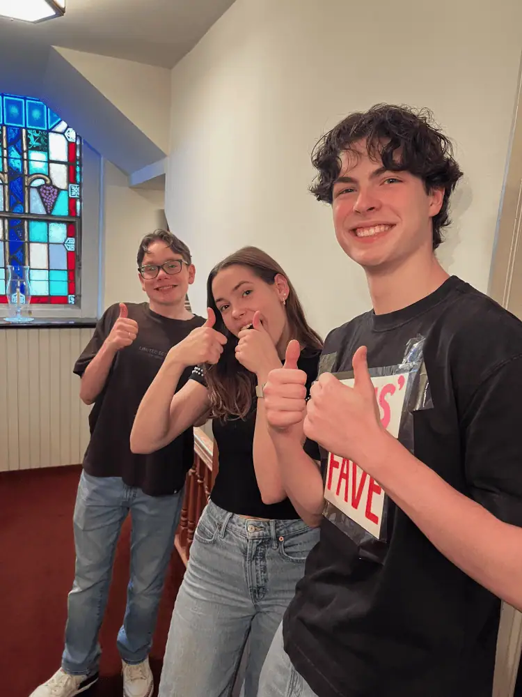 Three Schoeneckian youth are all smiles as they show two thumbs up at the camera.